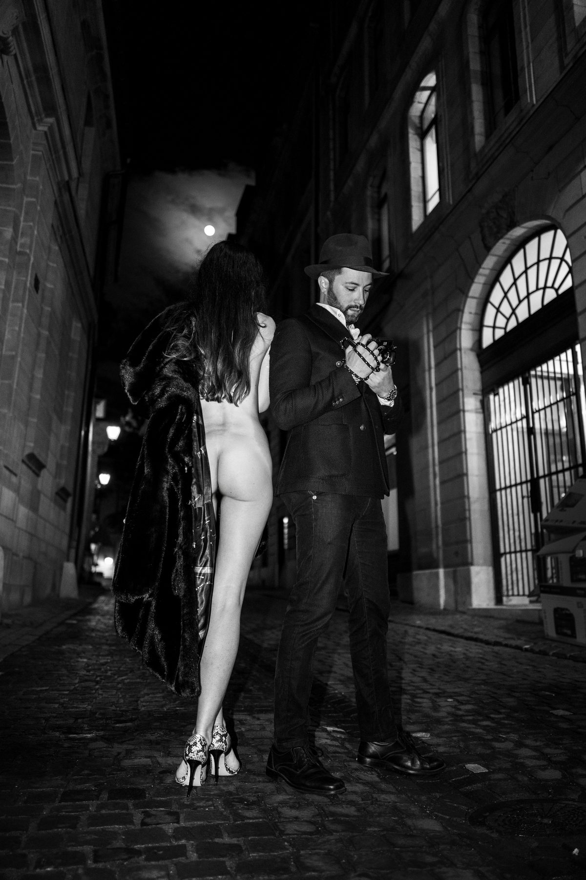 Night shoot in an old town street with a model in a fur coat