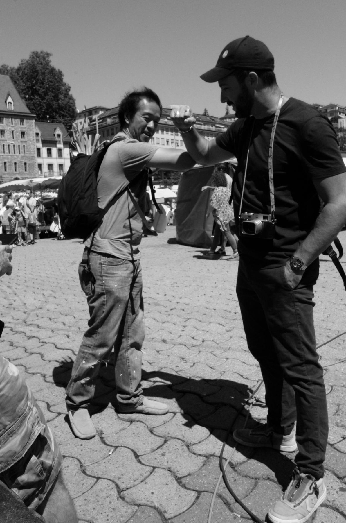 Jeremy Spierer guiding a student with his camera in a sunny square
