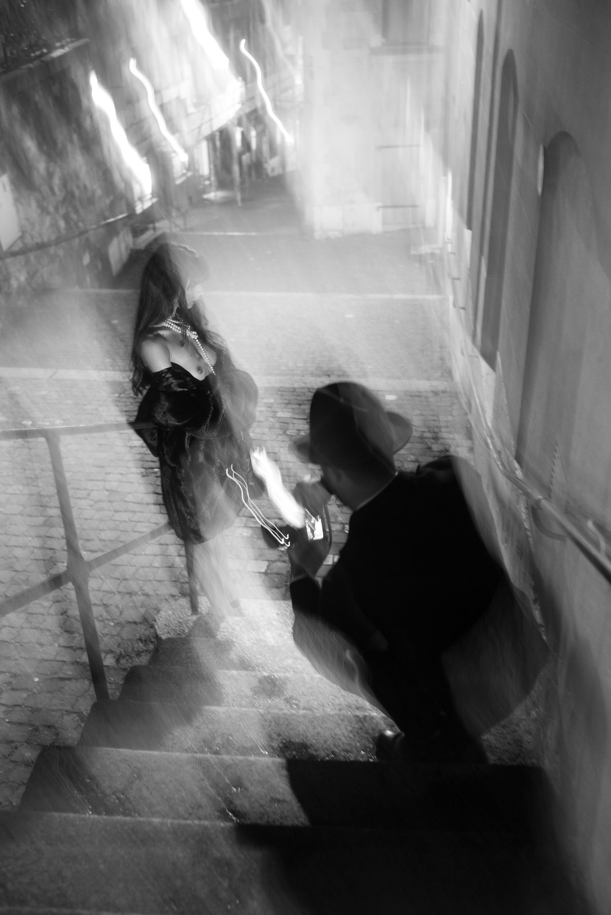 Blurred night shot of a model on stone steps and a photographer at work