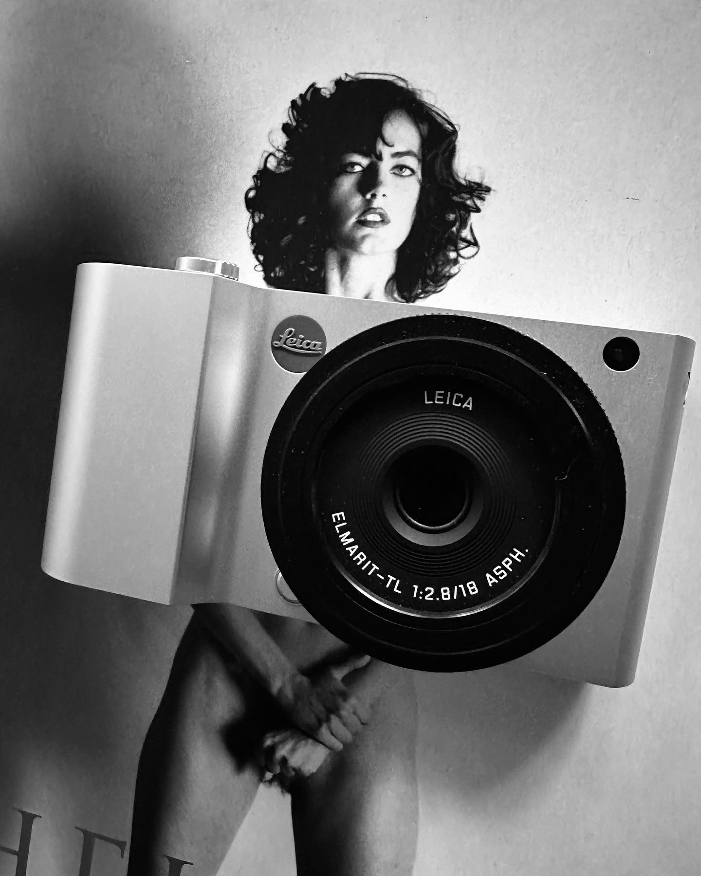 A model holding a Leica camera in front of her body