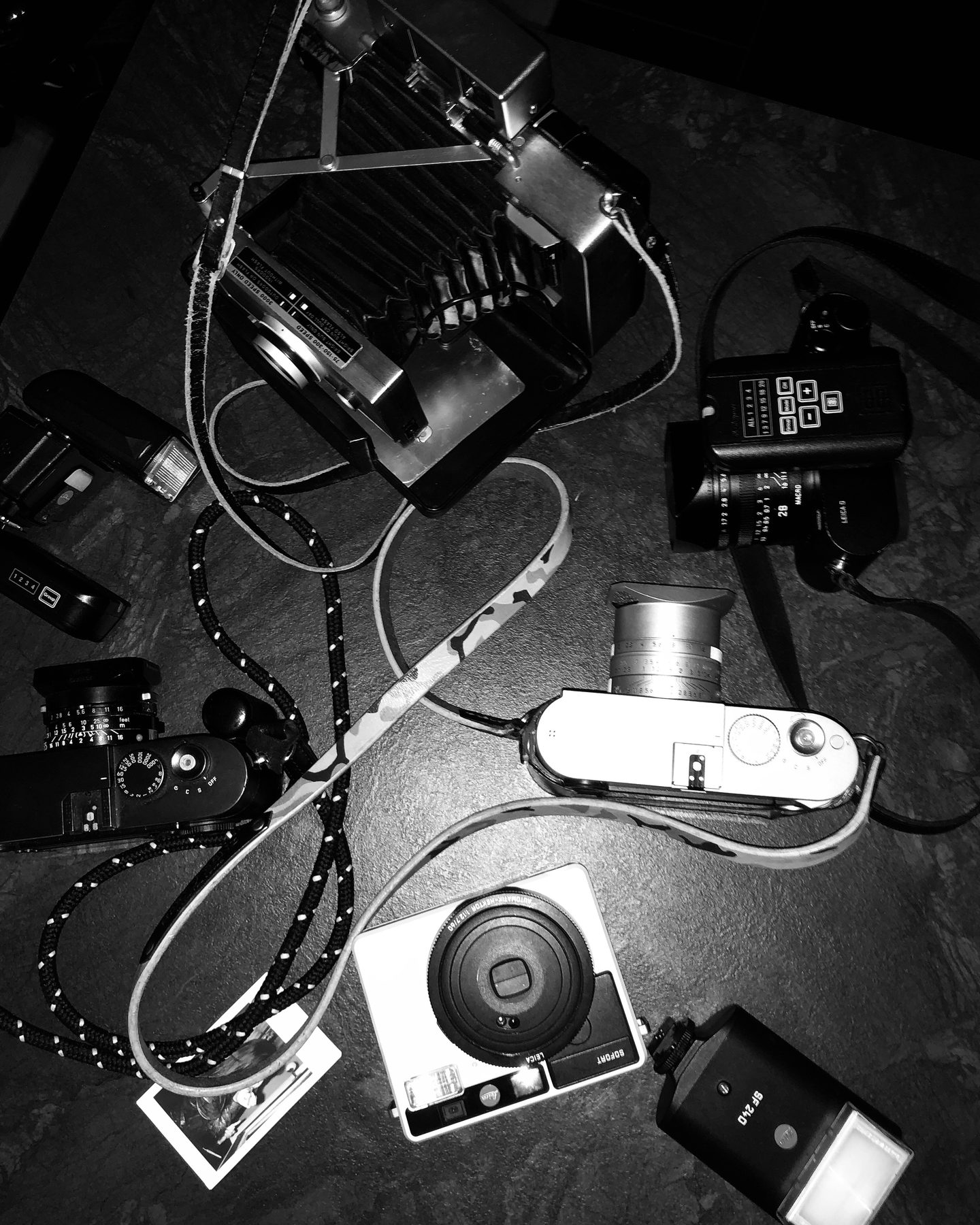 Cameras, flash and instant camera laid out before a shoot
